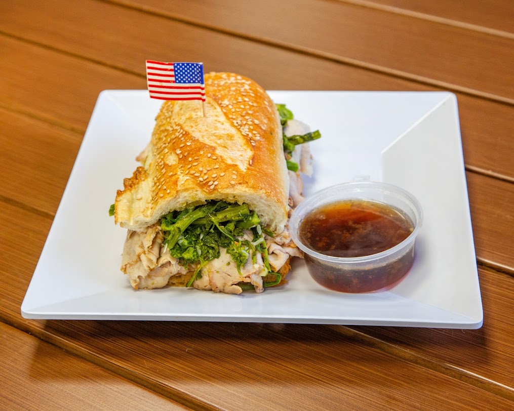 A Terrible Eddie’s hero with sliced meat, greens and a side of jus